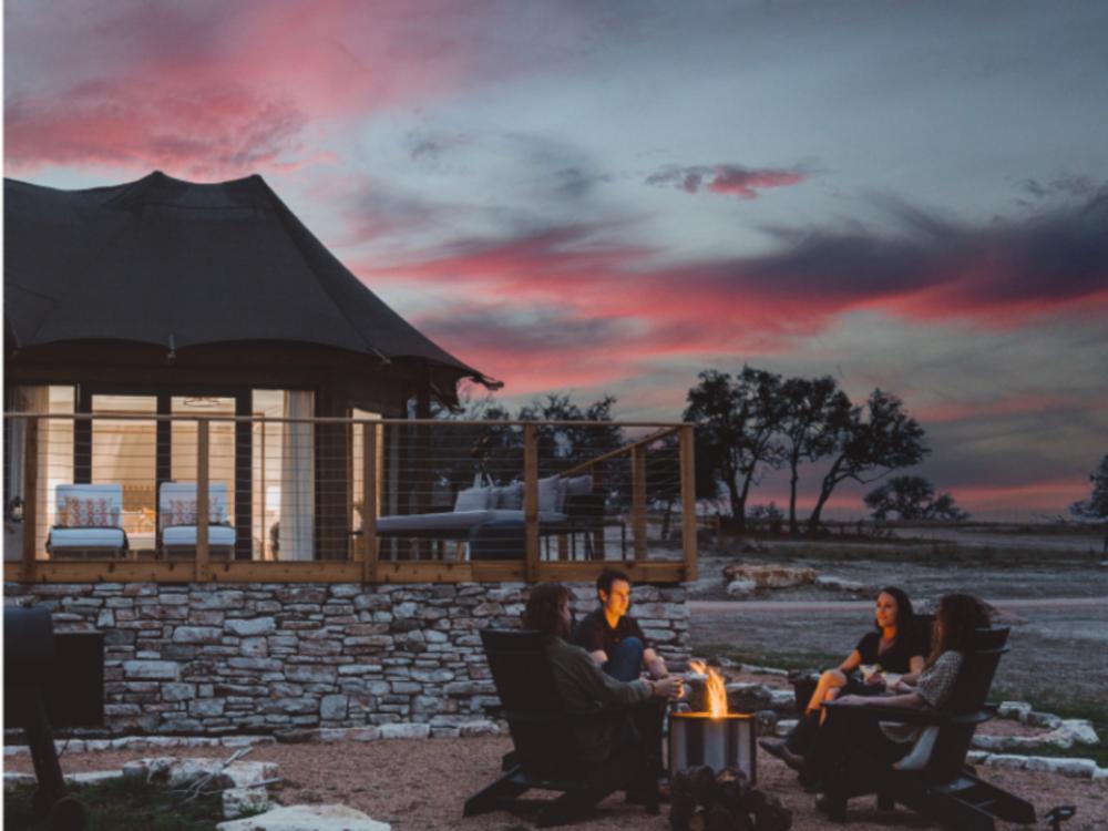People around a fire ring at sunset at Outdoorsy Hill Country
