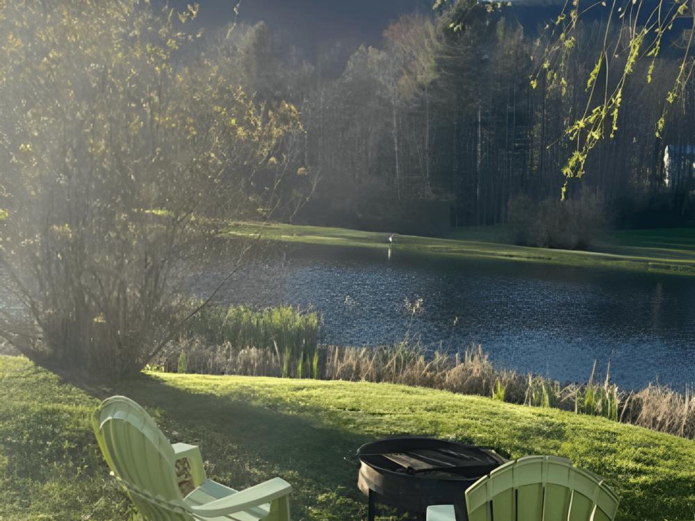 Chairs near fire pit and lake at site Route 6 Campground