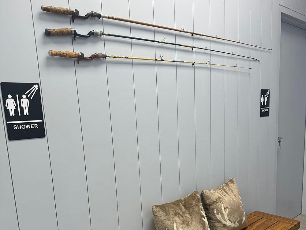 A bench under three fishing poles mounted to the wall