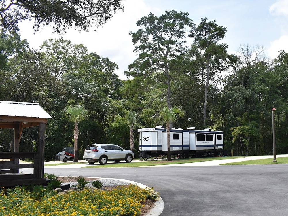 A fifth wheel trailer with a car in a site