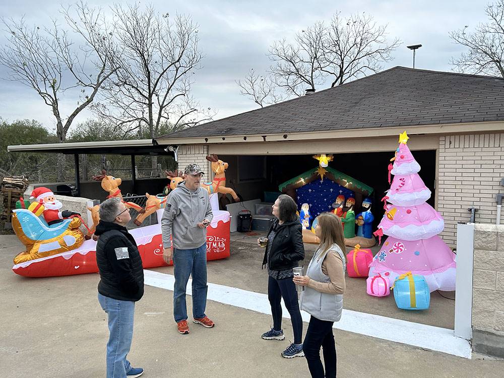 People chatting near a Christmas decorated house