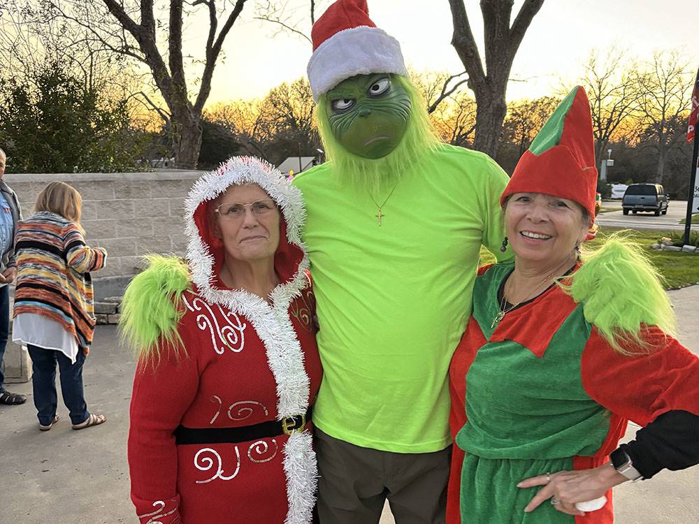 Three people dressed in Christmas themed costumes
