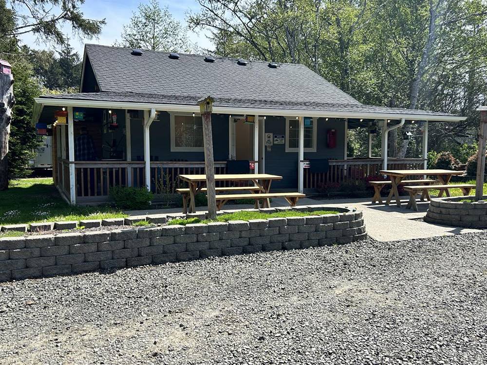 A brown building with picnic tables out front