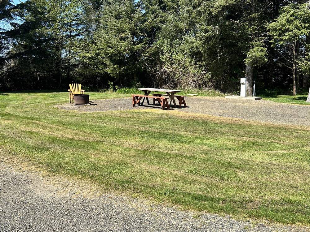 An RV site with picnic table and fire ring