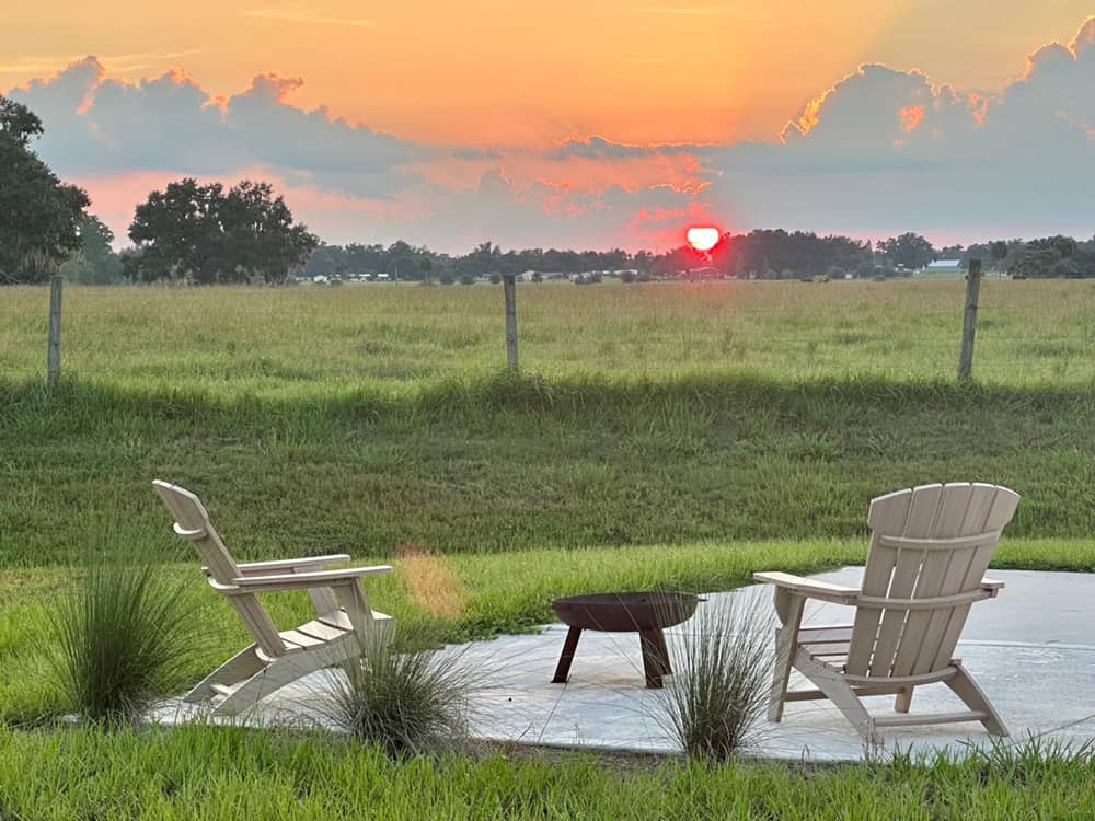 Chairs around a fire pit at sunset