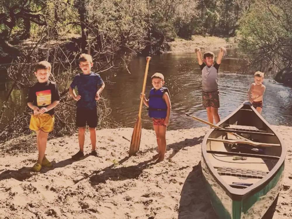 Kids on the shore with a canoe