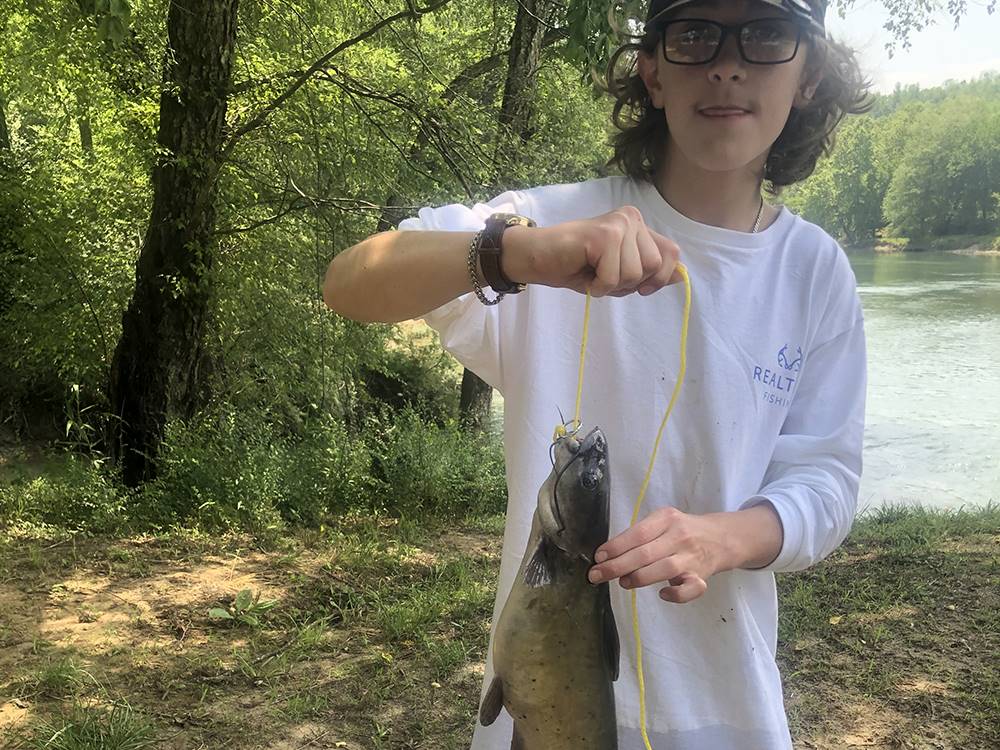 A boy holding a fish he caught