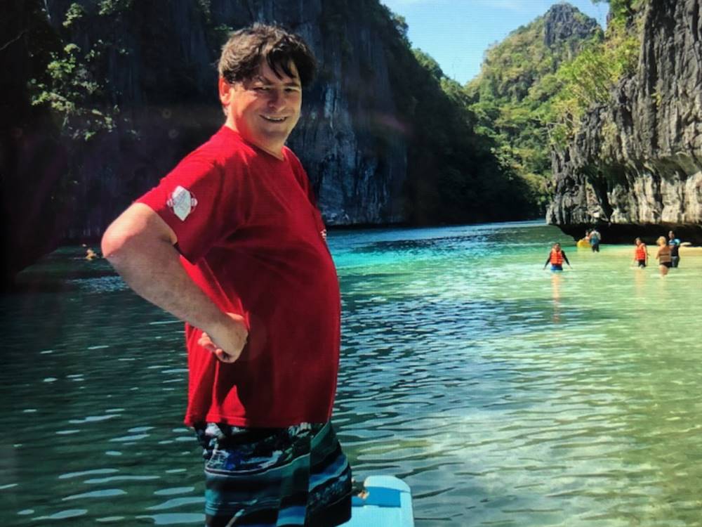 A man poses near the water