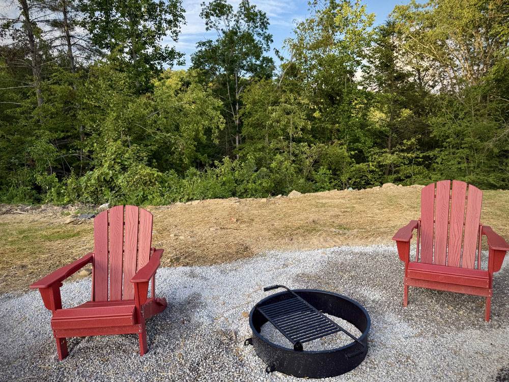 Adirondack chairs near a fire ring