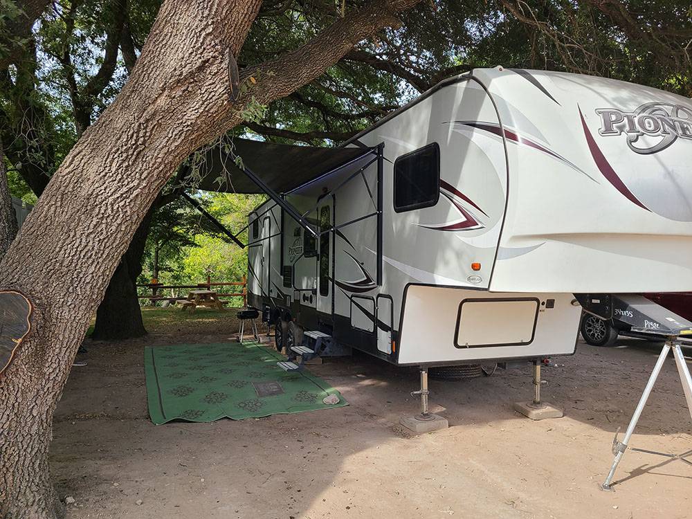 A fifth wheel in a shaded site