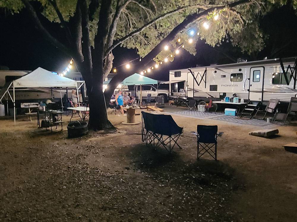 An RV site at night illuminated with patio lights