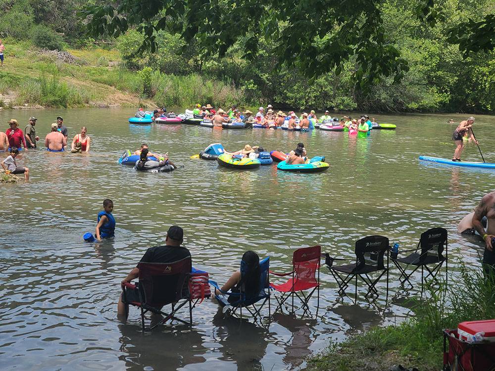 People floating and sitting in the river