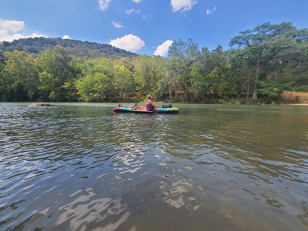 A couple people floating on the river