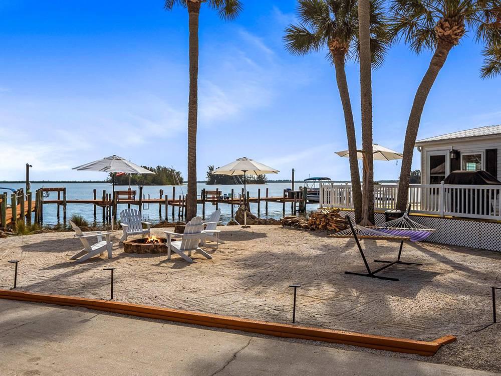A fire pit and hammock with a view of the river