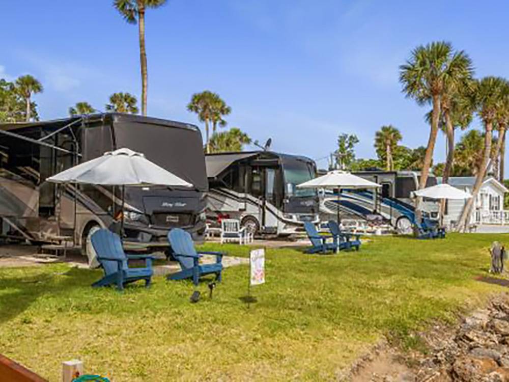 RVs and Adirondack chairs by the river