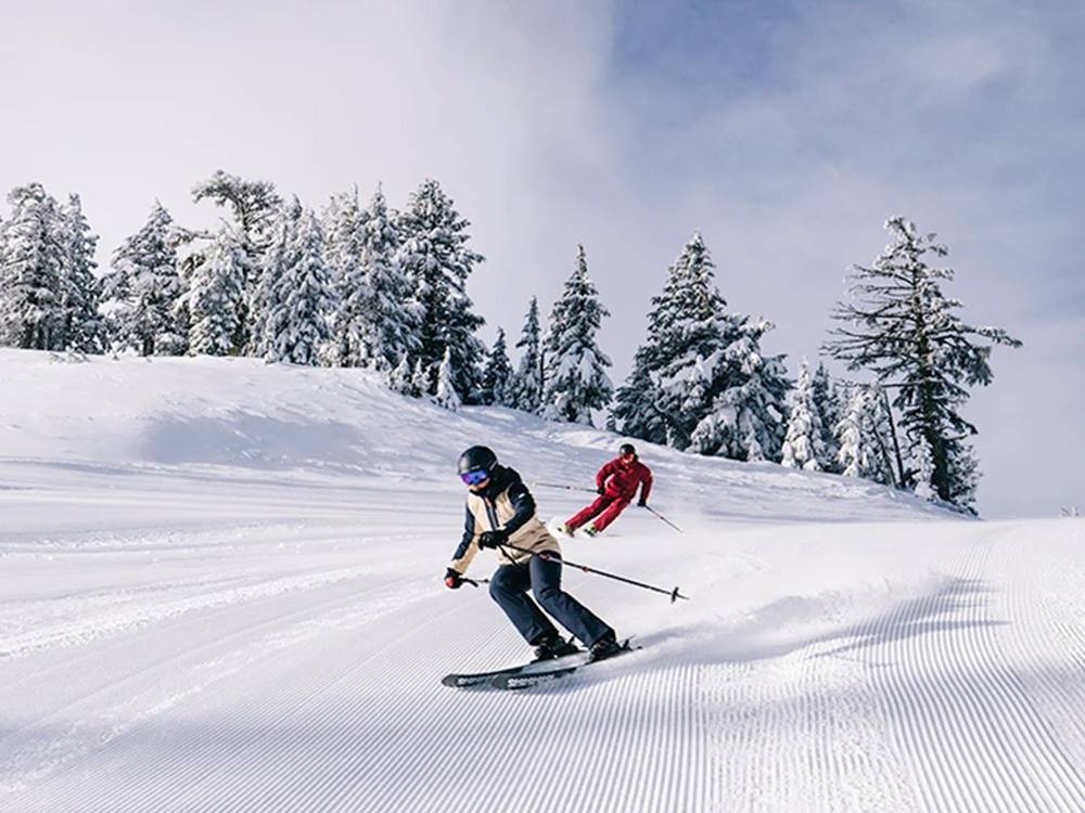 Two skiers going down hill