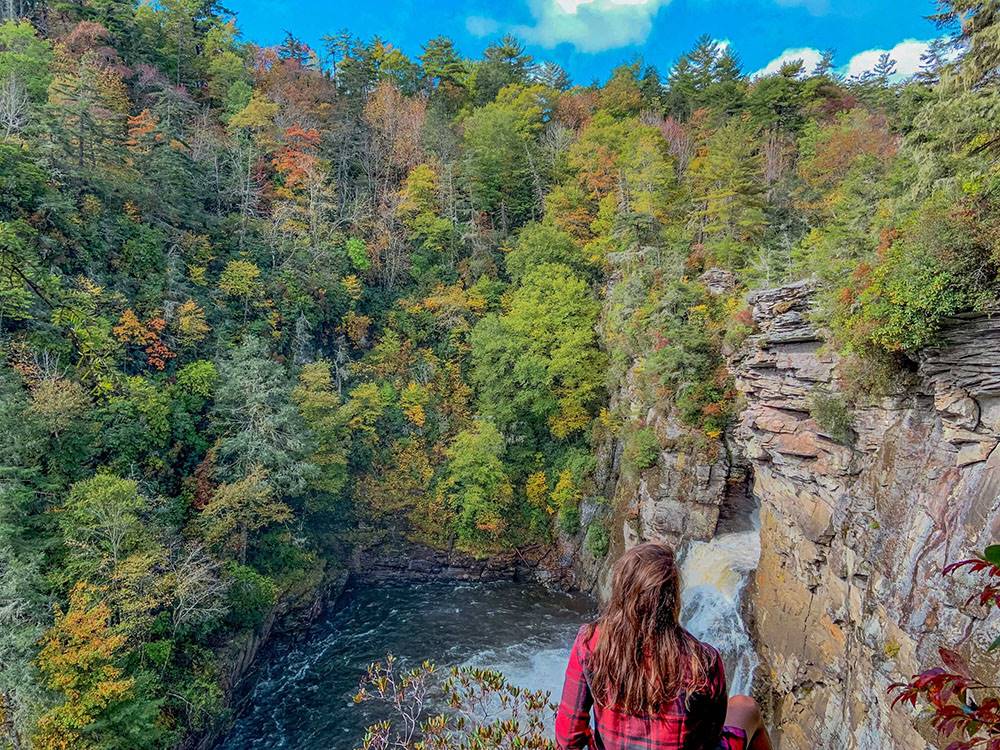 Person looking out over a waterfall chasm
