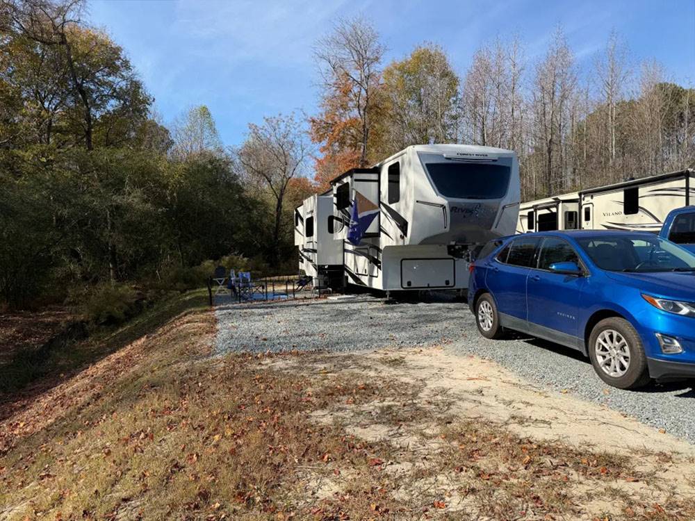 A blue car and fifth wheel parked at a site
