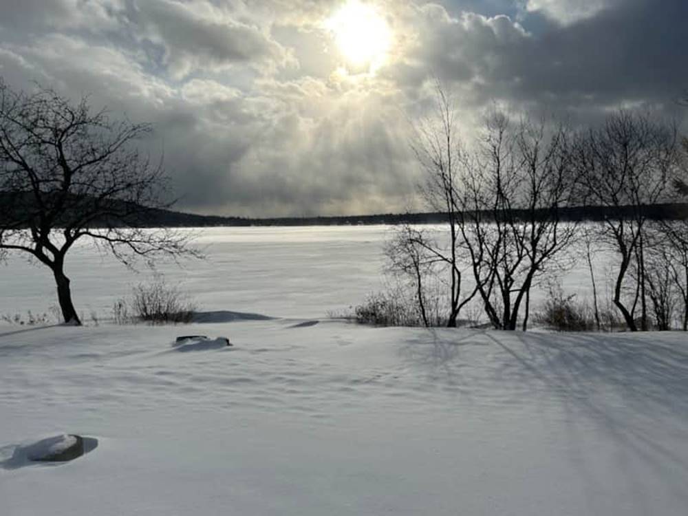 Snowy landscape with sun coming through clouds