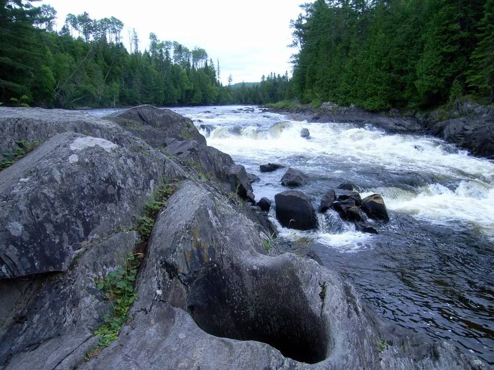 River flowing over rocks with trees in background