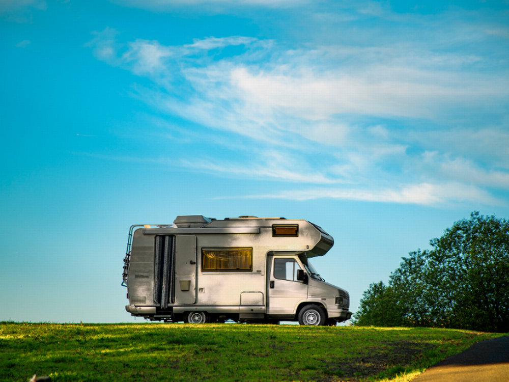 RV parked by a grassy field