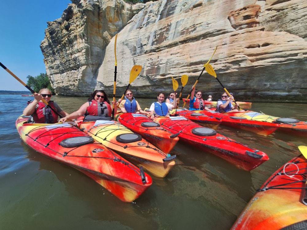 People in five kayaks posing for a photo