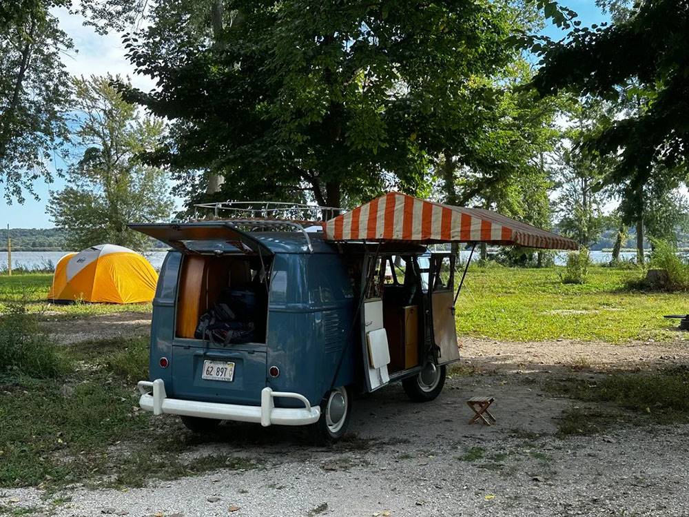 A vintage Volkswagen bus with an awning