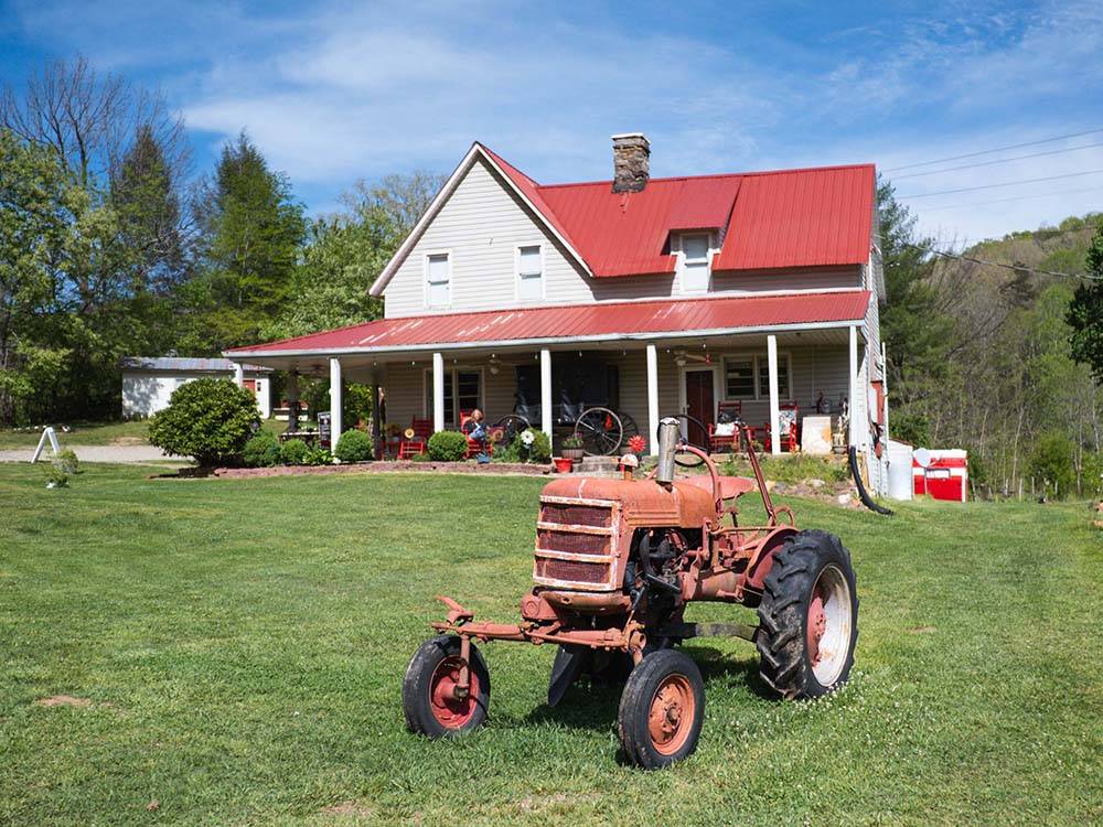An old tractor in front of a farmhouse