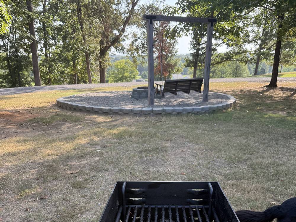A grill near a bench swing