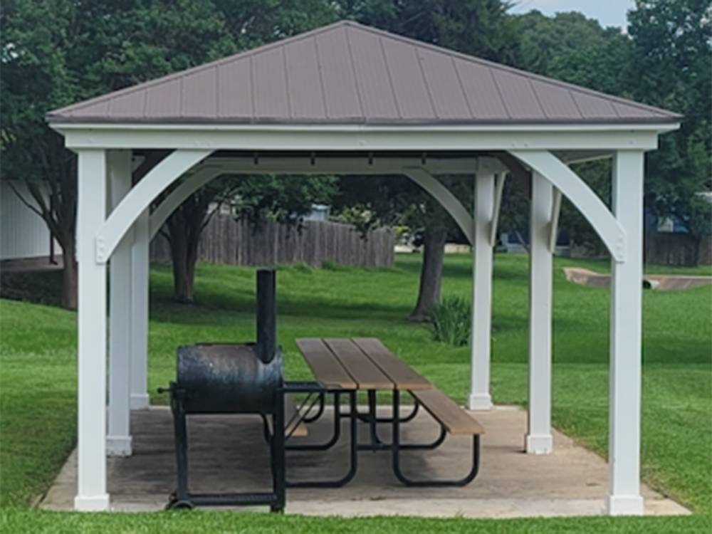 Picnic table and grill under a canopy