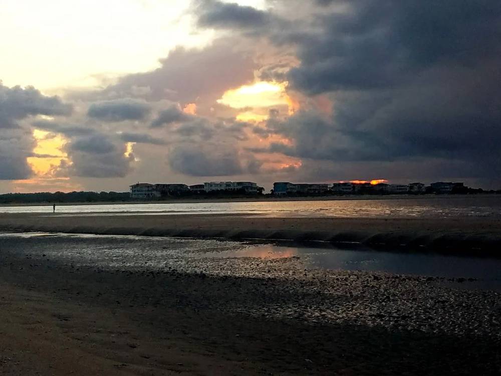 The sun sets behind clouds