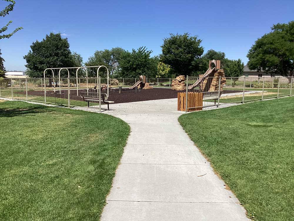 Paved footpath leads to play area with slides and swing sets at HEYBURN RIVERSIDE RV PARK