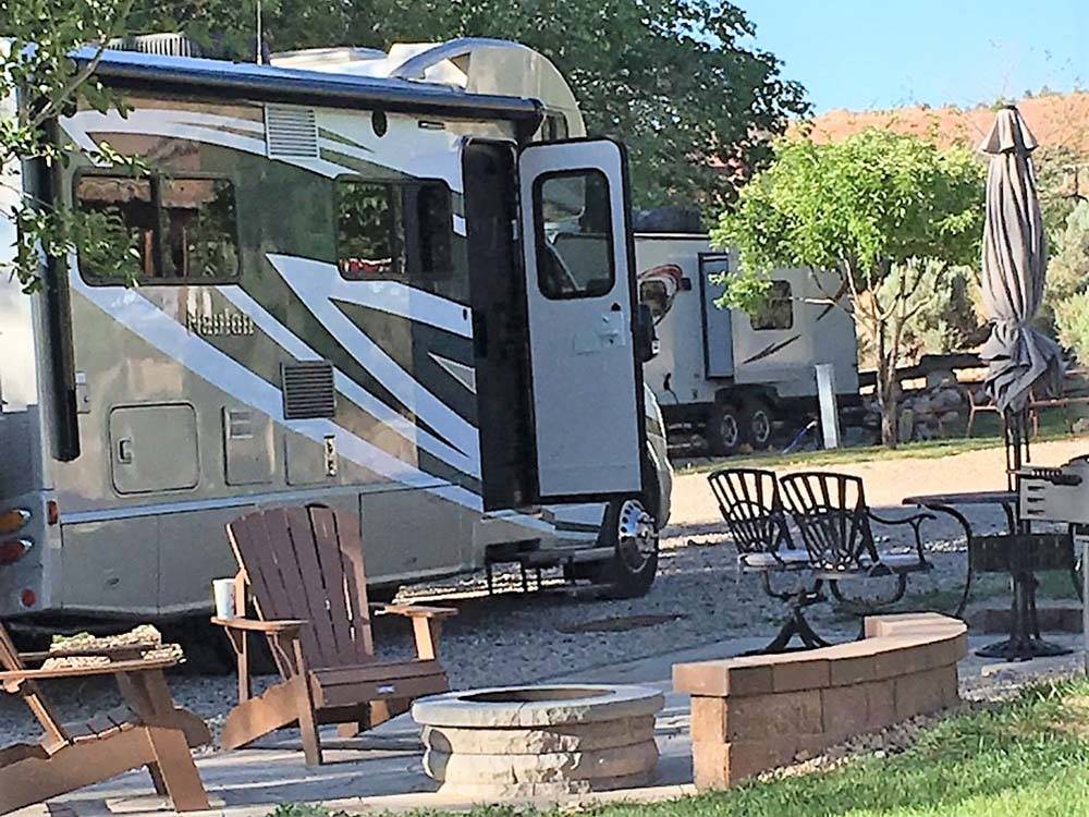 Motorhome parked in gravel site with fire pit at BRYCE CANYON RV RESORT BY RJOURNEY