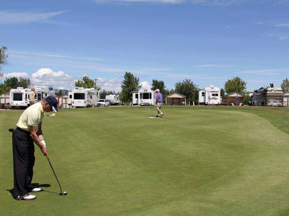 A couple of people playing golf at DEER PARK RV RESORT