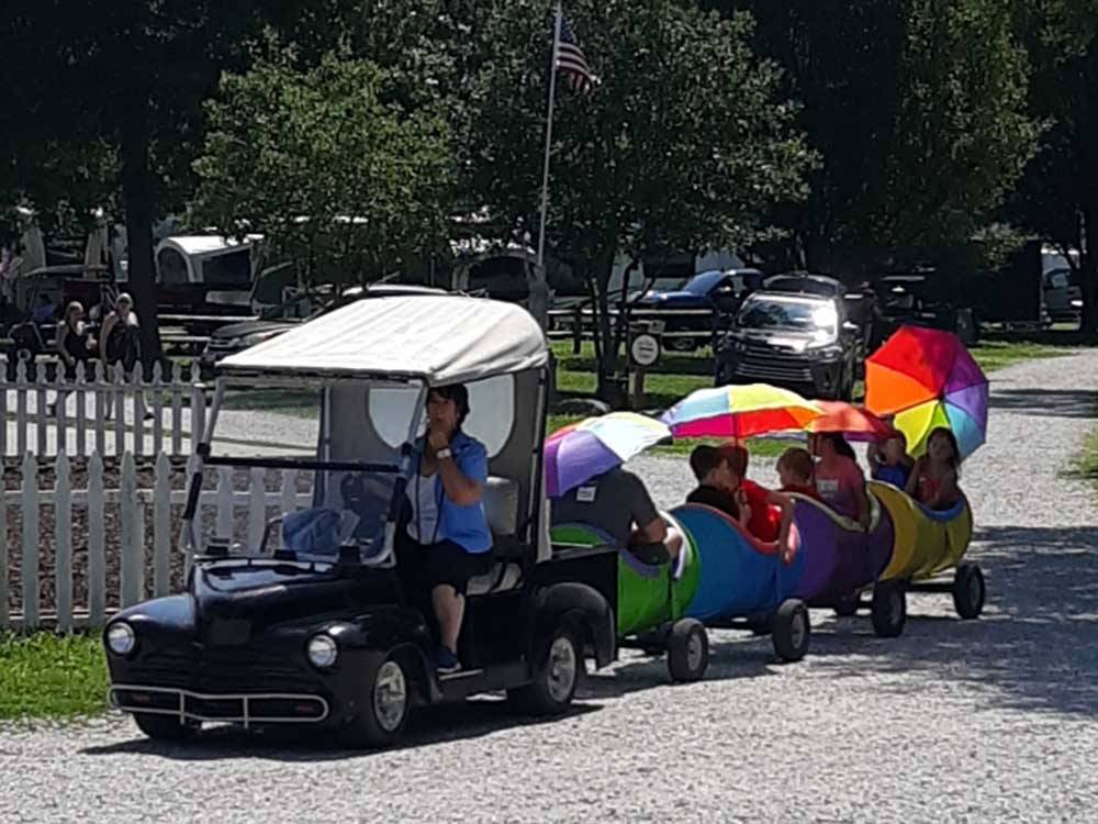Kids being towed around by golf cart at BEYONDER GETAWAY AT RISING SUN