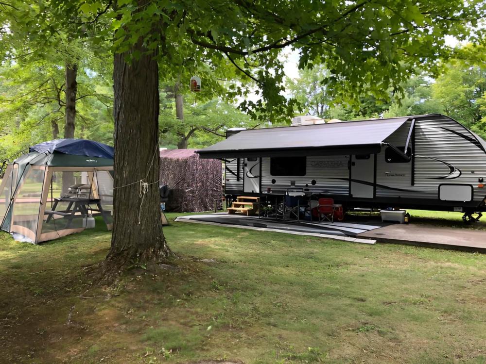 Parked trailer with covered patio at Twin Ells Campsite