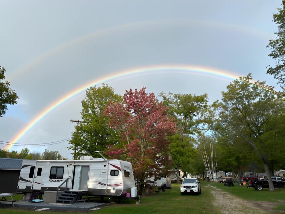 Parked trailer under a rainbow at Twin Ells Campsite