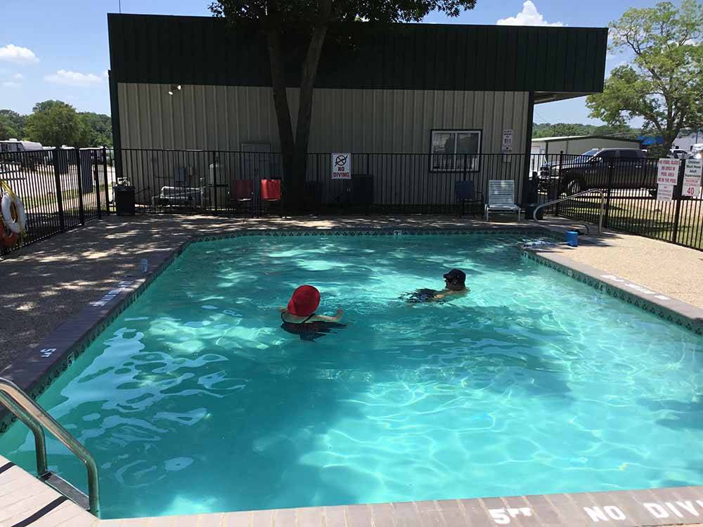 People playing in the swimming pool at LAZY L RV PARK
