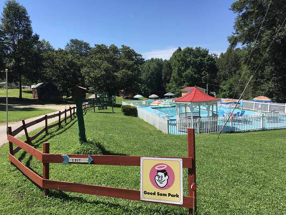 A wooden fence with the pool and gazebo in the background at FORT WILDERNESS CAMPGROUND AND RV PARK