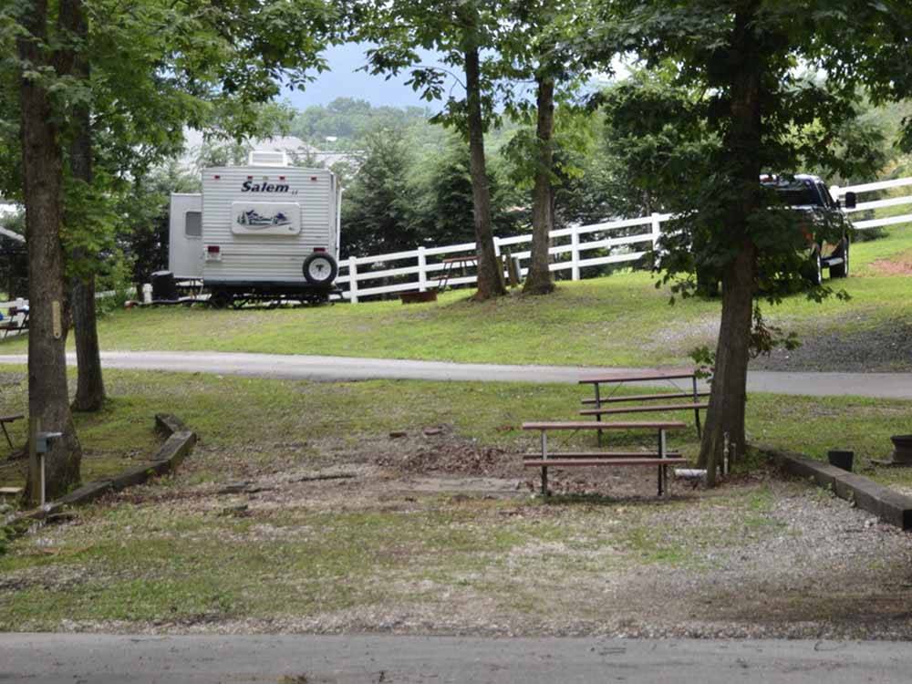 An empty RV site with benches at FORT WILDERNESS CAMPGROUND AND RV PARK