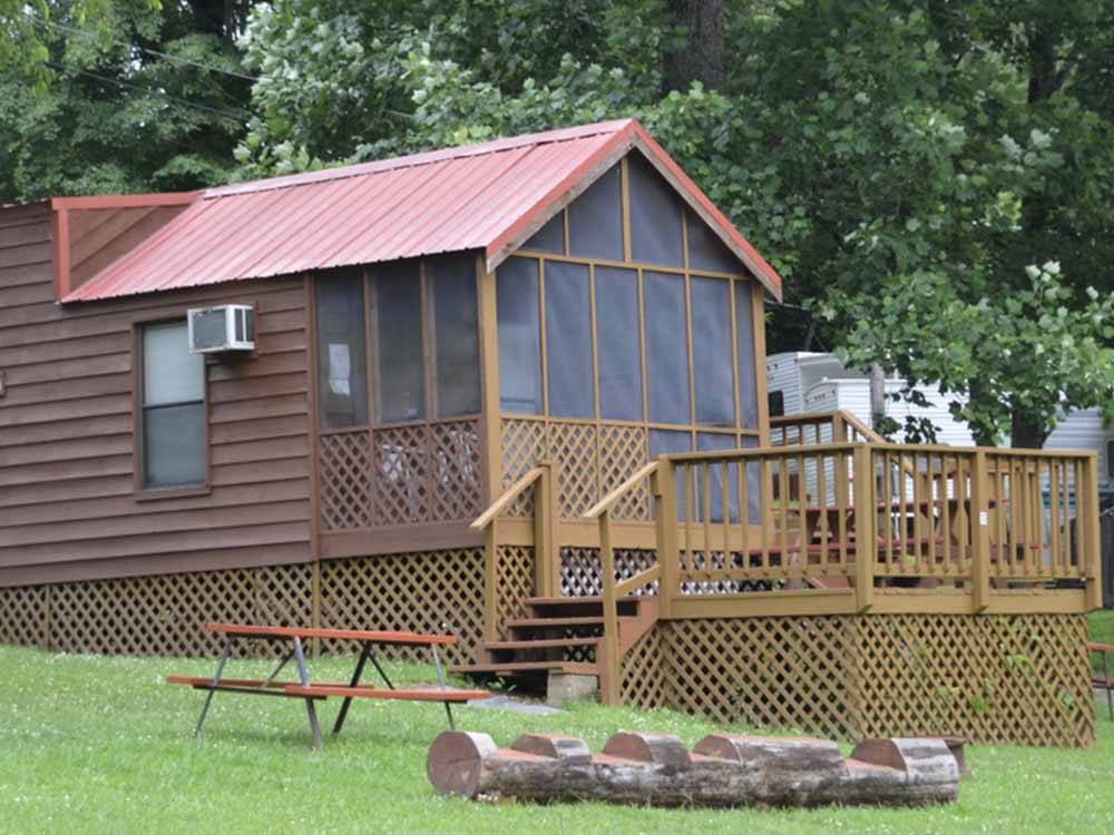 One of the rustic cabin rentals with a deck at FORT WILDERNESS CAMPGROUND AND RV PARK