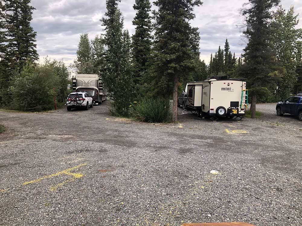 RVs in a group of gravel sites surrounded by trees at NORTHERN NIGHTS CAMPGROUND
