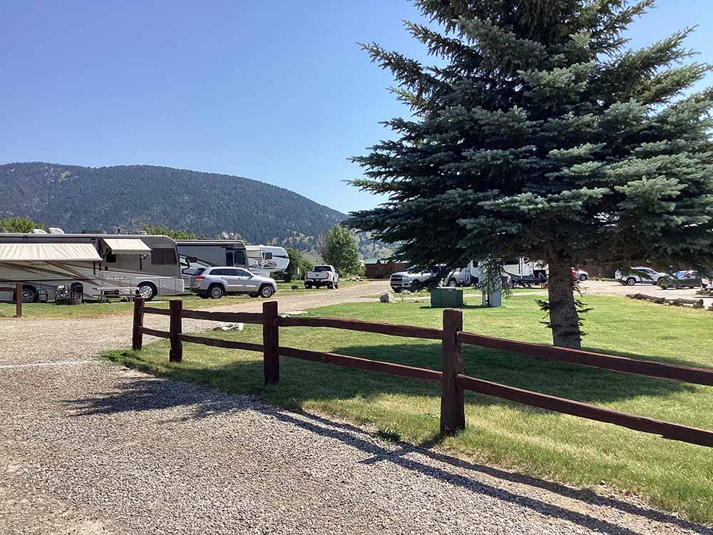 A wooden fence by the gravel road at YELLOWSTONE HOLIDAY RV CAMPGROUND & MARINA