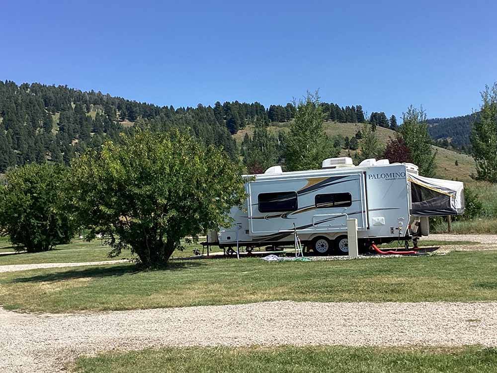 A trailer in a gravel RV site at YELLOWSTONE HOLIDAY RV CAMPGROUND & MARINA