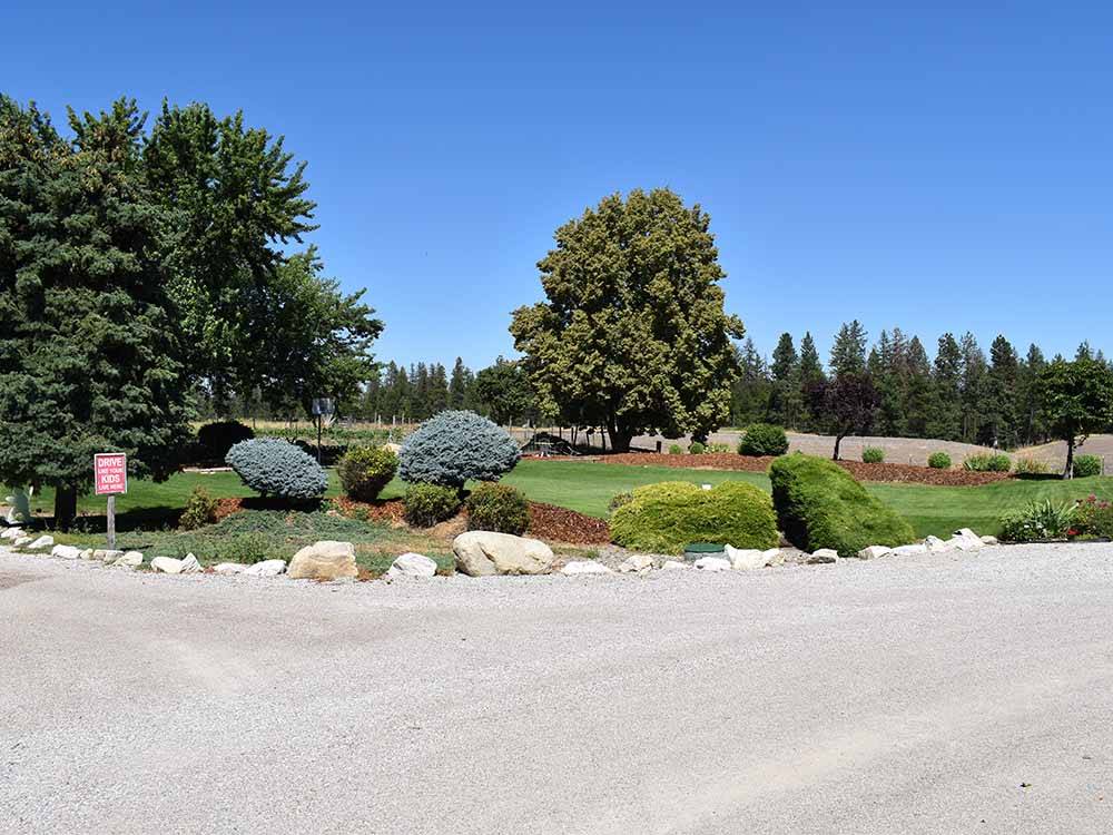 A grassy area near the gravel road at WILD ROSE RV PARK