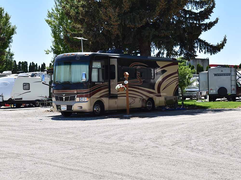 A motorhome in a gravel RV site at WILD ROSE RV PARK