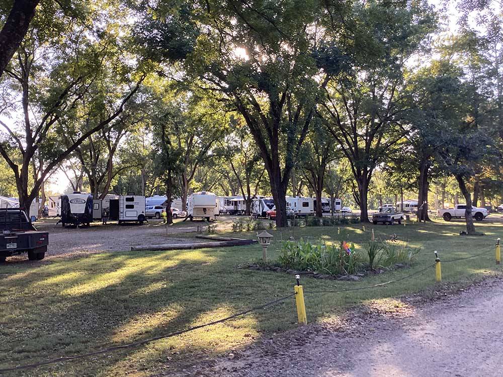 Trailers parked in sites under trees at PARK RIDGE RV CAMPGROUND