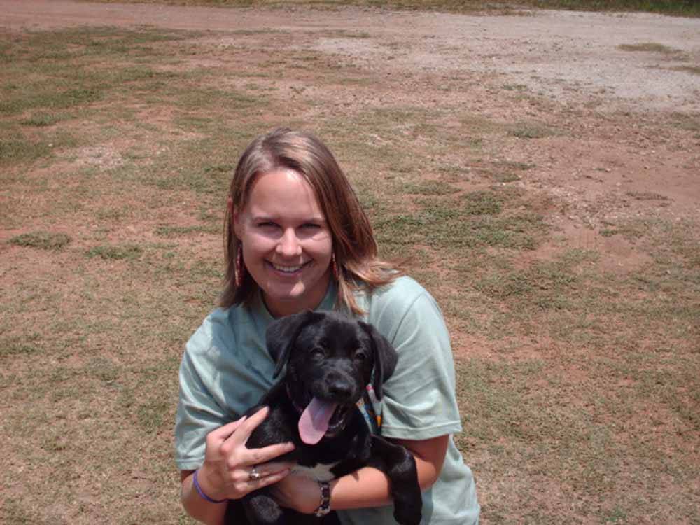 Lady holding a black lab puppy at MOON LANDING RV PARK & MARINA