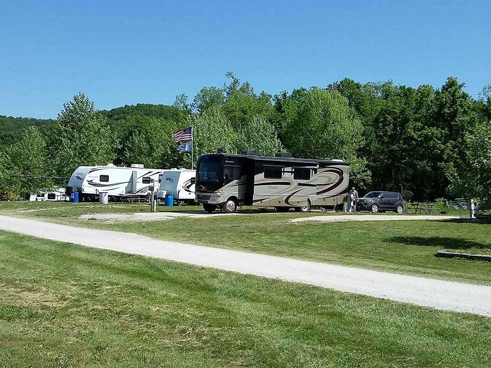 A row of trailers and motorhome parked in paved sites at BSC OUTDOORS CAMPING & FLOAT TRIPS