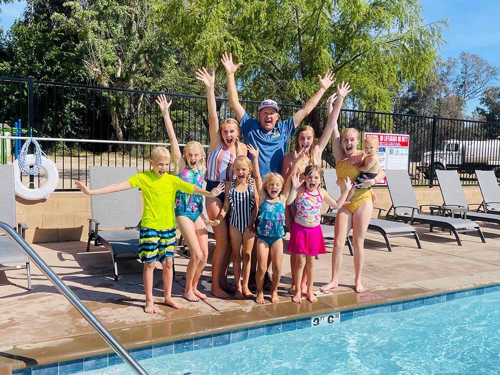 A group of kids celebrating by the pool at KINGS RIVER RV RESORT